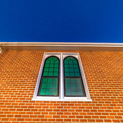 Square Sliding arched glas windows of a church in provo Utah against brick wall