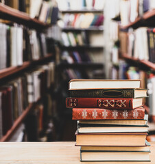 Stack of old vintage books on table in library, space for text