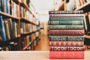 Stack of old vintage books on table in library, space for text