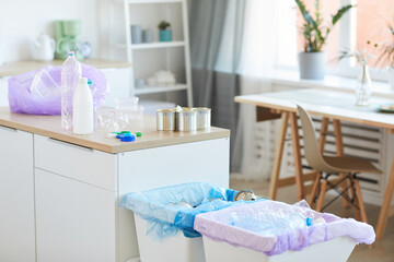 Image of plastic bottles cans and other garbage on the table being sorted in the bins