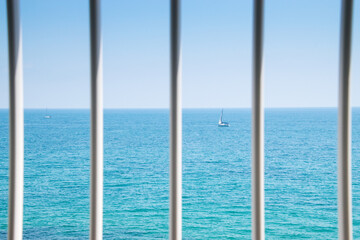 Ships behind bars. Blue sky and sea.