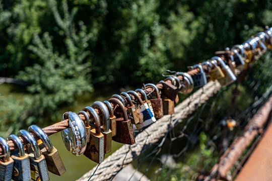 Different coloured locks left on the wire railing of a 100 year old bridge © Dylan