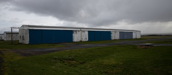 Obraz premium Abandoned airport hanger with large, locked storage rooms