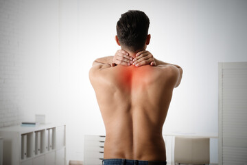 Man suffering from pain in neck at clinic