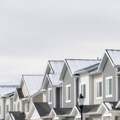 Square frame Facade of townhouses in South Jordan Utah with snowy gable roofs in winter