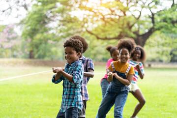 Group of Children having fun playing tug of war at the park, Group of children in a field trips. Sport and Field trip concept