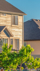 Vertical crop Sunny day view of home exterior with gray roof over sunlit wall and windows