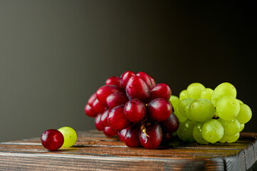 Red and green grapes on a wooden board
