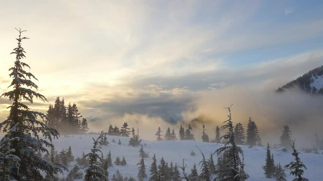 Panning shot of cottage amidst trees on snow covered landscape against sky at sunset - Elfin Lakes, British Columbia
