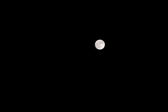 Full natural moon in black dark background during night