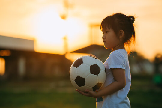 Kids playing soccer football under the sunset. Sport concept with copy space picture.