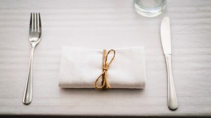 Minimalistic rustic table setting. Fork and knife, open air wedding in Italy