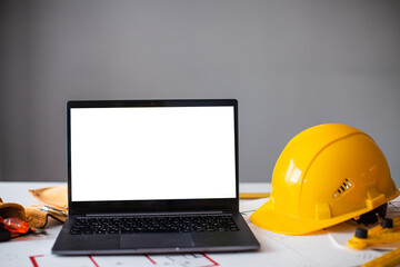 laptop and construction items, yellow helmet, apartment plan on the table, text, construction...