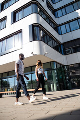 Young Man and Woman Walking Near Modern Building