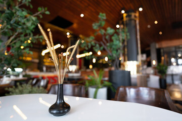 A dried wooden flower and leaf in black ceramic pot, using for decorate table in the lobby room. Selective focus at the dried flower part.