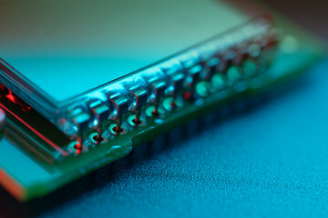 Macro shot of contacts on an LC display for a circuit board. Selective focus. Illuminated with red, blue and green light.