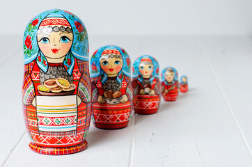 Five red matryoshka. Traditional Russian toy. Copy space. White wooden background