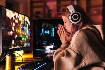 Image of stressed girl holding palms together while playing video game