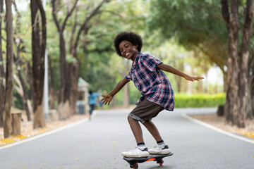 Happy young boy playing on roller blades, African American young boy riding on roller skates in the park, Kid playing on roller skates.