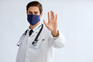 Male doctor wearing protective face mask to prevent from virus disease, studio.