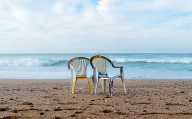 Fototapeta na wymiar Beach scene with a couple of empty chairs 