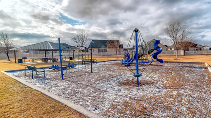 Panorama Playground with remnants of snow on the ground under sky filled with clouds