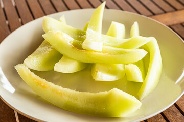 Sliced yellow melon on a white plate