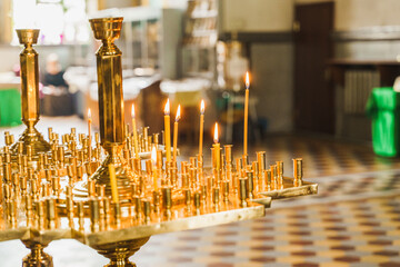 Candelabrum with burnings candles in church. Orthodox tradition and faith. Equipment for praying. Pray for people life. Pray to god