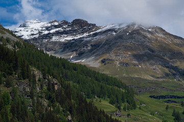 Fototapeta na wymiar Paesaggio di alta montagna tra sentieri e cime innevate