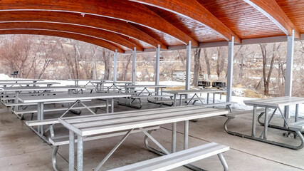Panorama Tables and benches inside a park pavilion with wooden arches on the ceiling
