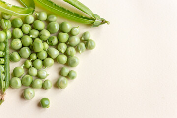 Fresh peas isolated on yelow background.Top view, selected focus. Heart shape.
