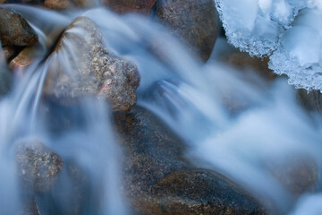 Landscape of winter waterfall framed by ice and captured with motion blur, Orangeville Creek, Michigan, USA