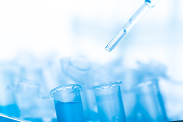 microbiological pipette in the genetic laboratory. study of a virus or vaccination. blue tinted.
