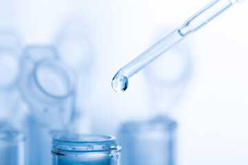 microbiological pipette in the genetic laboratory. study of a virus or vaccination. blue tinted.