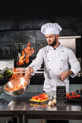 Chef prepare food with fire at kitchen restaurant. Chef with wok at kitchen.