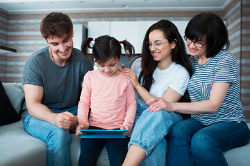 Big family at home. All together communicate online conferences on the tablet. Or play a fun mobile game