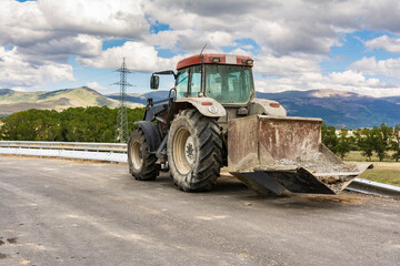 Tractor constructing a water pipeline ditch at road construction works