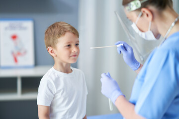 Portrait of a doctor taking a swab from a boy
