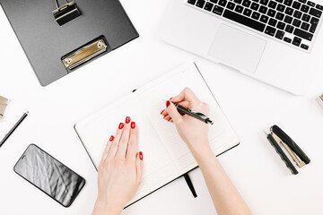 Woman hands with manicure work on workspace with eye glasses, laptop, smartphone, clipboard, notebook and a pen, paper clip, pencil, offi supplies on white background