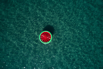 Watermelon swimming ring floating on a calm sea