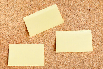 Mock up group of blank yellow stickers with pinned on cork board. Copy space
