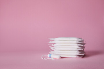 menstrual sanitary cotton pads and tampon on pink background. copy space. Feminine hygiene products