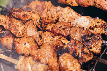 Grilled kebab background. Roasted meat cooked at barbecue. BBQ fresh pork meat chop slices. Traditional eastern dish, shish kebab. Grill on charcoal and flame, picnic, street food.