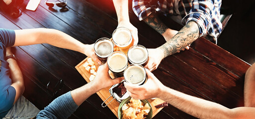 Group of friends toasting with beer in pub, above view. Banner design