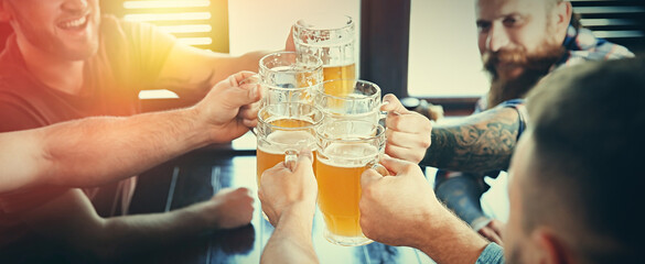 Group of friends toasting with beer in pub, closeup. Banner design