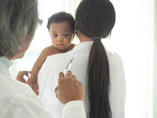 Hand of doctor hold syringe.Blur background is african baby boy.