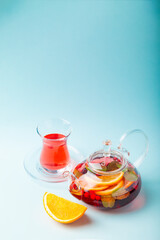 Fruit tea with berries in kettle, turkish shape tea cup