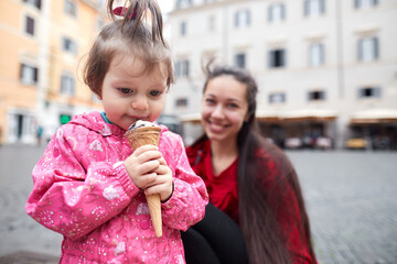 Mother and her daughter on the square eating ice cream