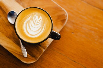 Cup of coffee latte on wooden background.