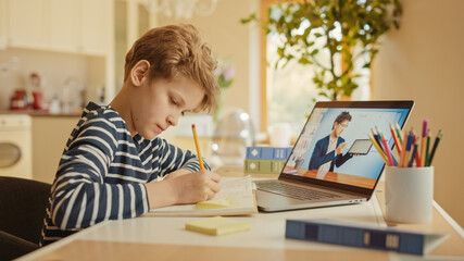 Smart Little Boy Uses Laptop for Video Call with His Teacher. Screen Shows Online Lecture with Teacher Explaining Subject from a Classroom. E-Education Distance Learning, Homeschooling.